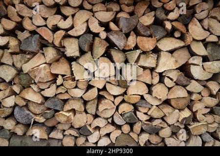 Gehacktes Holz, das im Freien auf einem Holzstapel oder Holzstapel gelagert wird. Stockfoto