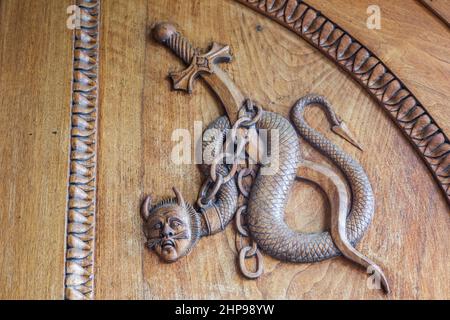 Symbol der Teufelsschlange. Fantasy magische Kreatur an einer alten Tür, 12th Jahrhundert Abtei, Italien. Stockfoto