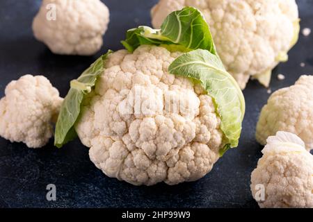 Roher Bio-Bauernhof Blumenkohl auf rustikalem Tisch Stockfoto