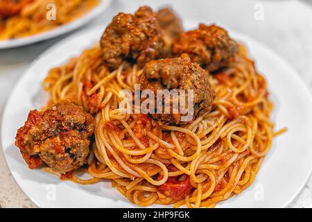 Rote Tomatensauce Spaghetti Pasta Nudeln Nahaufnahme mit Hackfleischbällchen auf dem Teller in Marinara-Sauce Stockfoto