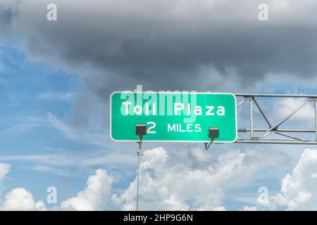 Schild für toll Plaza in 2 Meilen Spur für i75 Autobahn von Miami nach Naples in Florida und Wolken in blauem Himmel Stockfoto