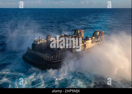 PAZIFISCHER OZEAN (Feb 18, 2022) Landungsschiff, Luftkissen an der Assault Craft Unit (ACU) 5 befestigt, führt Bohrdeckoperationen mit dem amphibischen Sturmschiff USS Essex (LHD 2) der Wasp-Klasse durch, 18. Februar 2022. Matrosen und Marineinfanteristen der Amphibious Ready Group (ARG) von Essex und der MEU von 11th sind im Gange, Routineoperationen in der US-3rd-Flotte durchzuführen. (USA Navy Foto von Mass Communication Specialist 3rd Klasse Isaak Martinez) Stockfoto