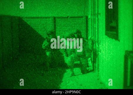 Soldaten der Vereinigten Arabischen Emirate mit 3rd Kompanie, 1st Bataillon, Al Forsan Brigade, Präsidentengarde, sorgen während einer nächtlichen Razzia-Trainingsübung im Marine Corps Air Ground Combat Center, Twentynine Palms, Kalifornien, am 15. Oktober 2021 für Sicherheit eines Marine Raiders mit Marine Forces Special Operations Command. Das U.S. Marine Corps und die VAE-PG pflegen durch fortwährende bilaterale Ausbildungsverpflichtungen und -Programme eine enge Beziehung, um die Fähigkeit der anderen zu verbessern, Terrorismusbekämpfungsoperationen durchzuführen, kritische Infrastrukturen zu schützen und die nationale Verteidigung zu unterstützen. (USA Marine Corps Foto von L Stockfoto