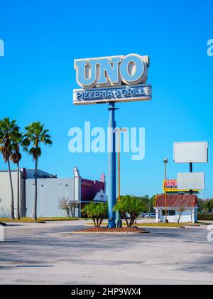 Kissimmee, Florida - 9. Februar 2022: Vertikale Weitansicht von Uno Pizzeria und Grill Restaurant Zeichen auf einer Tall Street Post. Stockfoto