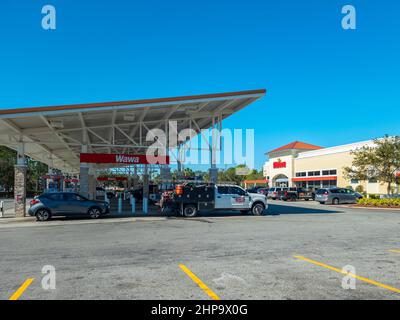 Kissimmee, Florida - 9. Februar 2022: Blick auf Wawa Convenience Store und Tankstelle mit Autotanken. Stockfoto