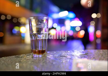 Hamburg, Deutschland. 20th. Februar 2022. Auf einem Tisch vor einer Kneipe auf der Großen Freiheit bei der Reeperbahn steht ein gebrautes Glas. In Hamburg trat am Samstag die erste Stufe der dreistufigen Aufhebung aller Corona-Maßnahmen in Kraft. Geimpfte und wiedergeborene Menschen können sich seit Mitternacht wieder in unbegrenzter Zahl privat treffen. Darüber hinaus wurden das Alkoholverbot für Einzelhändler und die Ausgangssperre im Gastronomiegewerbe aufgehoben. Quelle: Jonas Walzberg/dpa/Alamy Live News Stockfoto