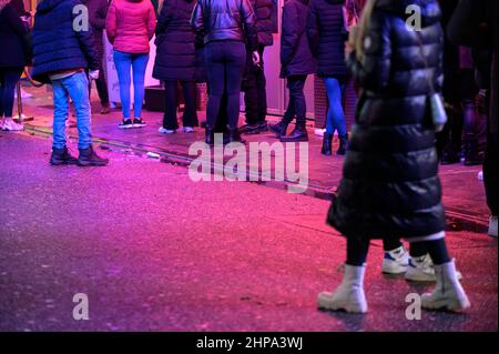 Hamburg, Deutschland. 20th. Februar 2022. Zahlreiche Partygänger warten vor einem Club auf der Großen Freiheit bei der Reeperbahn. In Hamburg trat am Samstag die erste Stufe der dreistufigen Aufhebung aller Corona-Maßnahmen in Kraft. Geimpfte und wiedergeborene Menschen können sich seit Mitternacht wieder in unbegrenzter Zahl privat treffen. Darüber hinaus wurden das Alkoholverbot für Einzelhändler und die Ausgangssperre im Gastronomiegewerbe aufgehoben. Quelle: Jonas Walzberg/dpa/Alamy Live News Stockfoto