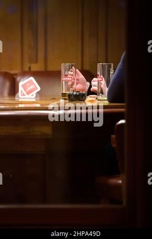 Hamburg, Deutschland. 20th. Februar 2022. Gebrauchte Biergläser stehen auf der Theke einer Bar auf der Großen Freiheit auf der Reeperbahn. In Hamburg trat am Samstag die erste Stufe der dreistufigen Aufhebung aller Corona-Maßnahmen in Kraft. Geimpfte und wiedergeborene Menschen können sich seit Mitternacht in unbegrenzter Zahl privat wiedersehen. Darüber hinaus wurden das Alkoholverbot für Einzelhändler und die Ausgangssperre im Gastronomiegewerbe aufgehoben. Quelle: Jonas Walzberg/dpa/Alamy Live News Stockfoto