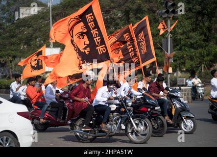 Gruppe junger Männer auf Motorrädern, die Safranfahnen mit Grafiken des Maratha-Königs Shivaji Maharaj zu seinem Geburtstag halten. Lage: Na Stockfoto