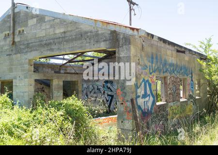 Ruatoria Neuseeland - Februar 4 2022; Graffiti bedeckte verödelte Industriegebäude in abgelegener Lage. Stockfoto