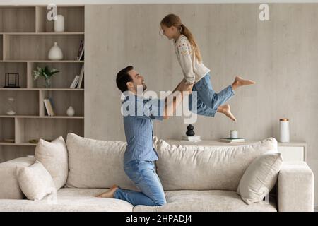Aufgeregt glücklich starken Vater hebt fröhliche Tochter Stockfoto
