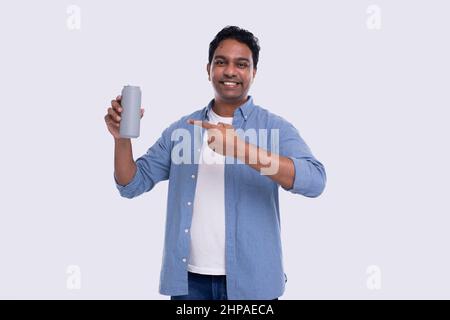 Indischer Mann, der Zinn hält, kann darauf zeigen. Indischer Mann mit Bierzinn in der Hand. Isoliert Stockfoto