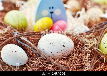 Osterhintergrund mit bunten Eiern im Nest. Draufsicht mit Kopierbereich Stockfoto