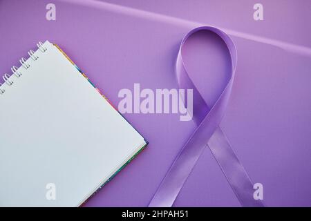 Notizblock und violettes Band zum Purple Day - Welt-Epilepsietag, März 26. Symbol des Epilepsietages. Stockfoto