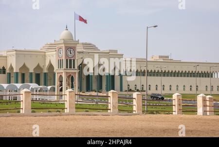 Qatar Nationalflagge über Amiri Diwan Parlamentsgebäude und Uhrturm, Doha, Katar Stockfoto