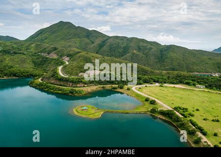 Hubschrauberlandeplatz mit künstlich anmausem See zwischen dem Kasernendamm und dem Hauptdamm des High Island Reservoir West Dam, Sai Kung East Country Park, Hongkong Stockfoto