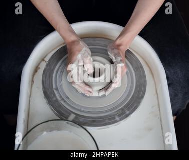 Hände auf dem Töpferrad, Draufsicht Stockfoto