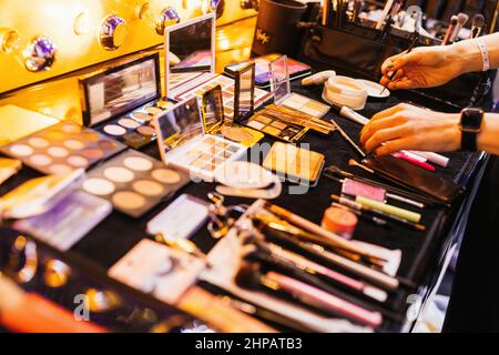 Rust, Deutschland. 19th. Februar 2022. Die Hände eines Make-up-Künstlers sind neben Make-up-Utensilien zu sehen. 160 Teilnehmer wurden im September zu den sogenannten 'Live Experiences' nach Hamburg eingeladen. Gleichzeitig bedeutet diese Änderung, dass es nicht wie üblich 16 Finalisten im Finale geben wird, sondern dass es eine Top 10 geben wird, aus der die neue Miss Deutschland im heutigen Finale ausgewählt wird. Quelle: Philipp von Ditfurth/dpa/Alamy Live News Stockfoto