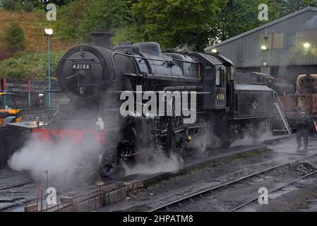 Der Zugfahrer führt am frühen Morgen Kontrollen an der Ex LMS-Dampflok 43106 im Bridgnorth-Motorschuppen der Severn Valley Railway durch Stockfoto