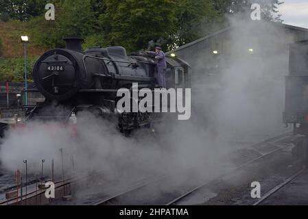 Der Zugfahrer führt am frühen Morgen Kontrollen an der Ex LMS-Dampflok 43106 im Bridgnorth-Motorschuppen der Severn Valley Railway durch Stockfoto