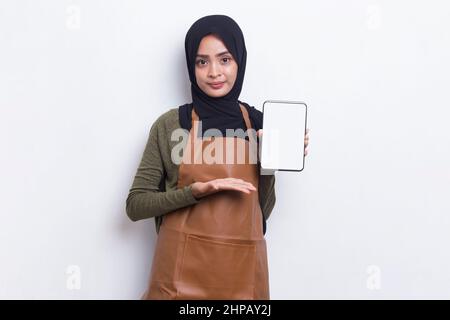 Asiatische muslimische Barista Kellnerin demonstriert Handy auf weißem Hintergrund Stockfoto