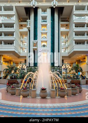 Orlando, Florida - 9. Februar 2022: Vertikale Ansicht der Haupthalle des Terminals B im Inneren des internationalen Flughafens von Orlando (MCO) mit Brunnen im Vordergrund und Stockfoto