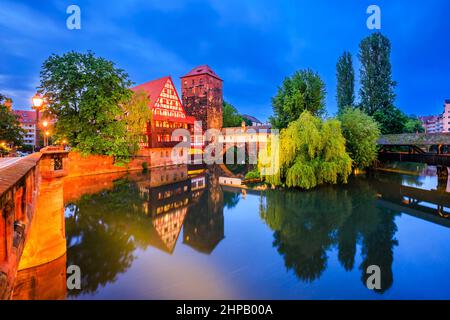 Nürnberg, Deutschland. Das Weinlager (Weinstadel) und die Hängebrücke (Henkersteg) bei Nacht. Stockfoto