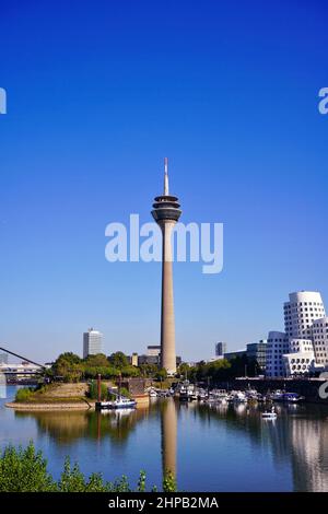 Medienhafen in Düsseldorf mit Düsseldorfs Wahrzeichen, dem Rheinturm, und modernen Gehry-Gebäuden von Frank O. Gehry. Stockfoto