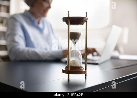 Nahaufnahme der Sanduhr, die auf dem Tisch steht. Stockfoto