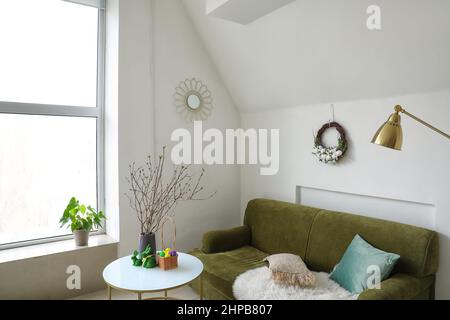 Osterkranz, der an einer hellen Wand im Innenraum hängt Stockfoto