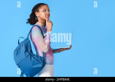 Afroamerikanische Studentin mit Laptop auf blauem Hintergrund Stockfoto