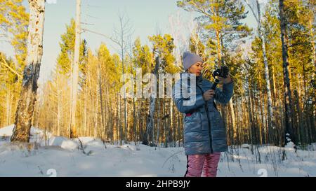 Frau, die auf einem Handheld-Film hält 3-Achsen-Gimbal-Stabilisiergerät im Winter für Smartphone. Girl Blogger Make Selfie, Broadcast Video Blogging, Vlogging. Videograf Operator Nimmt Fotovideo Auf. Stockfoto