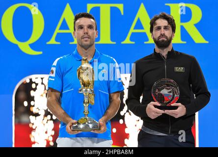 Doha. 19th. Februar 2022. Roberto Bautista Agut (L) aus Spanien und Nikoloz Basilashvili aus Georgien posieren für Fotos während der Preisverleihung nach dem ATP Qatar Open Tennisturnier-Finale im Khalifa International Tennis Complex in Doha, 19. Februar 2022. Kredit: Nikku/Xinhua/Alamy Live Nachrichten Stockfoto