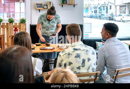 Junge Köchin, die eine Kochwerkstatt gibt Stockfoto