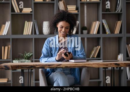 Glücklich schöne junge afroamerikanische Frau mit Handy. Stockfoto