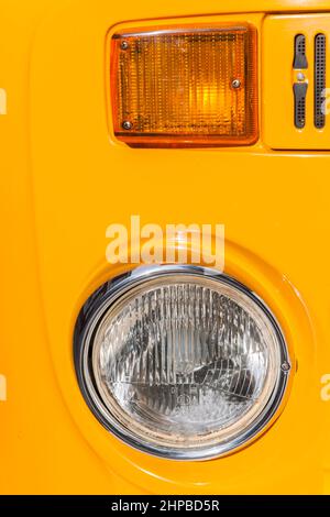 Esens, Deutschland - 19. September 2021: Frontale Nahaufnahme des Scheinwerfers und Blitzlicht eines orangefarbenen Minibus der 1970er Jahre bei einem Oldtimer-Treffen. Stockfoto