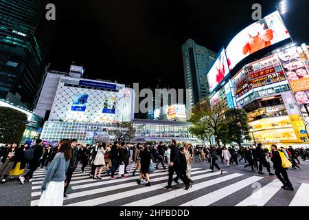 Shibuya, Japan - 1. April 2019: Der berühmte Shibuya überquert den Crosswalk und kriegt Wahrzeichen der Innenstadt und Menschen drängen sich durch kommerzielle Werbung Stockfoto