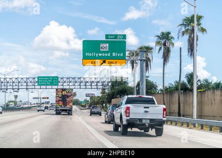 Miami, USA - 5. August 2021: Viele Autos fahren auf der Autobahn Straße im Verkehr mit Ausschilderung zum Hollywood Beach Boulevard, Florida und Palmen o Stockfoto