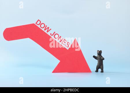 Dow Jones Industrial Average oder DJIA Index in rotem Abwärtspfeil mit abnehmenden Münzstapel. Pessimistische Entwicklung am US-amerikanischen Aktienmarkt. Stockfoto