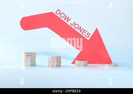 Dow Jones Industrial Average oder DJIA Index in rotem Abwärtspfeil mit abnehmenden Münzstapel. Pessimistische Entwicklung am US-amerikanischen Aktienmarkt. Stockfoto