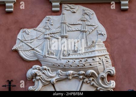Relief von Galeone-Segelschiff in Wellen auf historischen Mietshaus Fassade auf Swietojanska Straße in der Altstadt von Warschau in Polen. Stockfoto