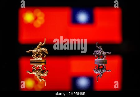 Konzeptuelles Bild des Krieges zwischen China und Taiwan mit Spielzeugsoldaten und Nationalflaggen auf einem reflektierenden Hintergrund Stockfoto