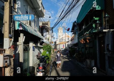 Ban Yuan, eine alte Siedlung vietnamesischer und kambodschanischer Einwanderer in Bangkok, Thailand; b/g: Die Unbefleckte Empfängnis-Kirche, Thailands erste Kirche Stockfoto