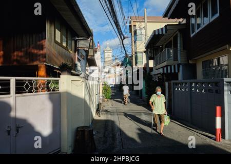 Ban Yuan, eine alte Siedlung vietnamesischer und kambodschanischer Einwanderer in Bangkok, Thailand; b/g: Die Unbefleckte Empfängnis-Kirche, Thailands erste Kirche Stockfoto