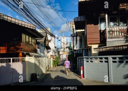 Ban Yuan, eine alte Siedlung vietnamesischer und kambodschanischer Einwanderer in Bangkok, Thailand; b/g: Die Unbefleckte Empfängnis-Kirche, Thailands erste Kirche Stockfoto