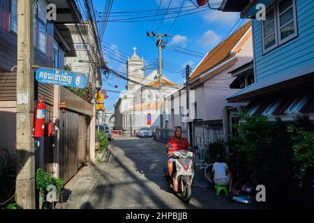 Ban Yuan, eine alte Siedlung vietnamesischer und kambodschanischer Einwanderer in Bangkok, Thailand; b/g: Die Unbefleckte Empfängnis-Kirche, Thailands erste Kirche Stockfoto