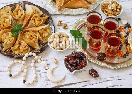 Ramadan Kareem festlich, Fasten, Halal-Essen. Ramadan-Menü: Gemischtes arabisches Pfannkuchen-Katayef und Datteln, Pistazie. Stockfoto