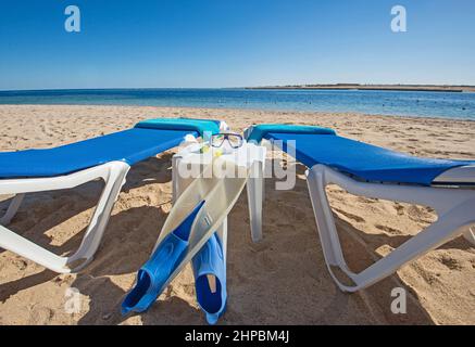 Blick auf das Meer am tropischen Hotelresort-Strand mit Sonnenliegen und Schnorchelausrüstung Stockfoto