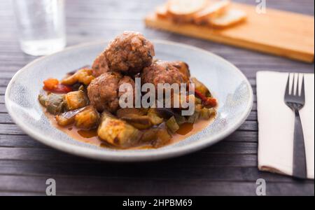 Gebackene Fleischbällchen mit geschmorter Aubergine, Zucchini, grünen Paprika und Tomaten mit Dunst in einer Schüssel Stockfoto