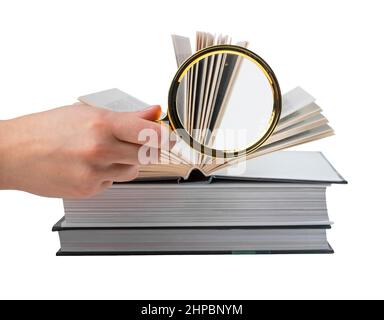 Hand hält Lupe in der Nähe Bücher Stapel isoliert auf weißem Hintergrund. Informationssuche und Analyse Konzept. Hochwertige Fotos Stockfoto